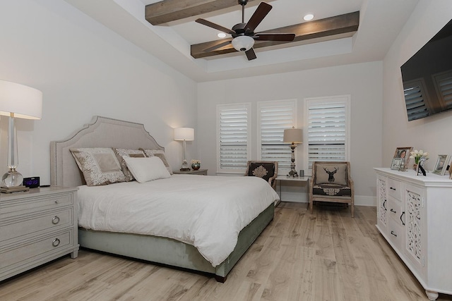 bedroom featuring beamed ceiling, ceiling fan, a raised ceiling, and light hardwood / wood-style floors