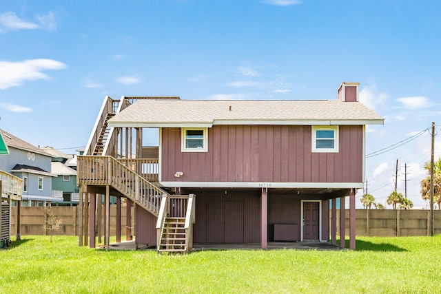 back of house with a wooden deck and a lawn