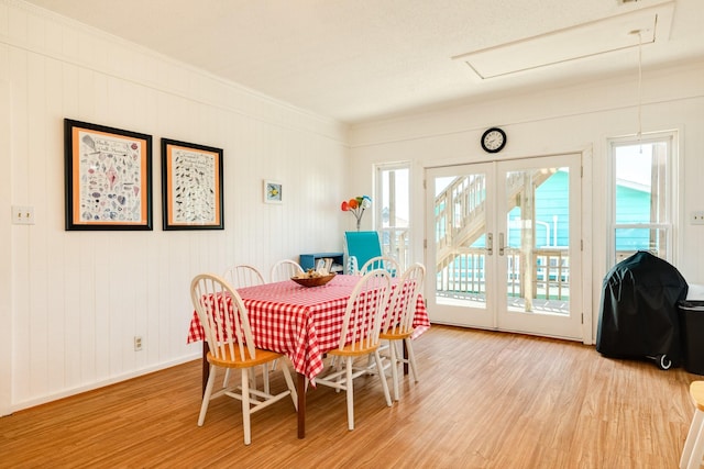 dining room with crown molding, light hardwood / wood-style floors, and french doors