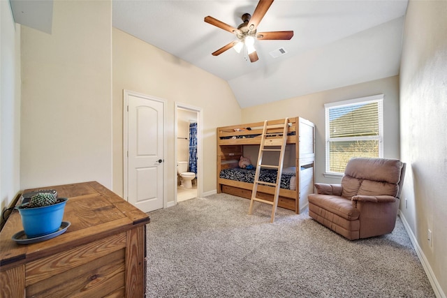 bedroom featuring ceiling fan, connected bathroom, vaulted ceiling, and carpet