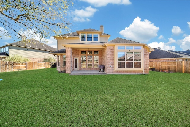 rear view of property featuring a yard and a patio area