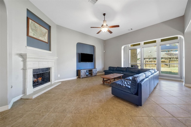 living room with ceiling fan, light tile patterned flooring, and a fireplace