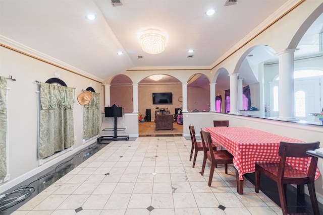 dining space with light tile patterned floors, crown molding, vaulted ceiling, and decorative columns