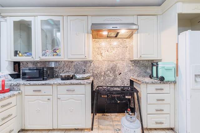 kitchen featuring extractor fan, backsplash, white cabinets, white refrigerator with ice dispenser, and light stone counters