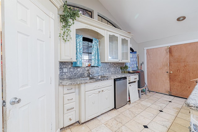 kitchen featuring sink, tasteful backsplash, vaulted ceiling, dishwasher, and white cabinets