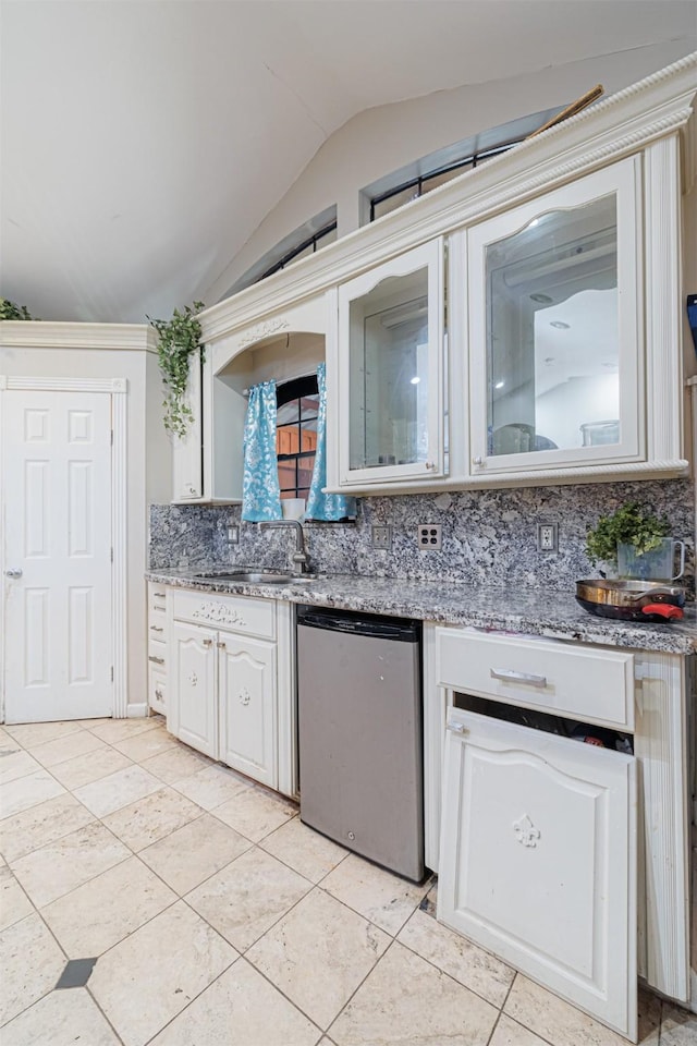 kitchen featuring vaulted ceiling, dishwashing machine, backsplash, light tile patterned floors, and light stone counters