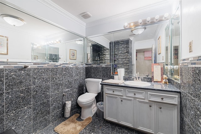 bathroom featuring vanity, ornamental molding, tile walls, and toilet