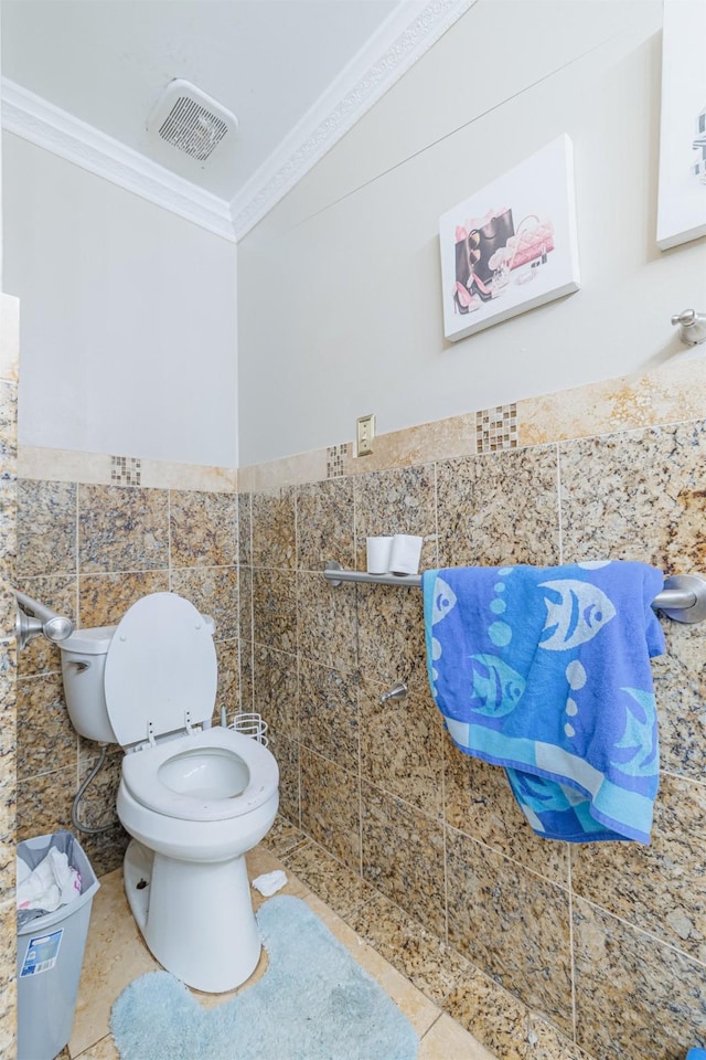 bathroom featuring tile walls, crown molding, tile patterned floors, and toilet