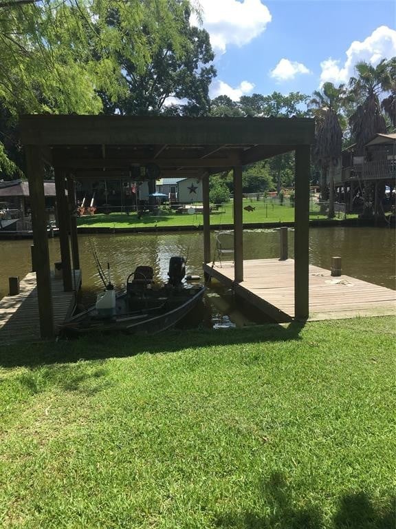 view of dock featuring a water view and a lawn