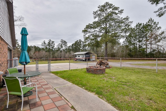 view of yard with an outbuilding, an outdoor fire pit, fence, and a gate