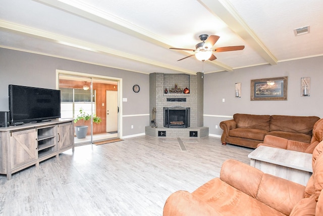 living area featuring light wood-style floors, visible vents, beamed ceiling, and baseboards