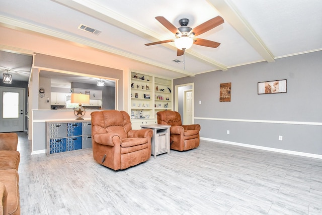 living area featuring light wood finished floors, visible vents, ornamental molding, beamed ceiling, and baseboards