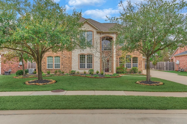 view of front of house with central AC and a front lawn