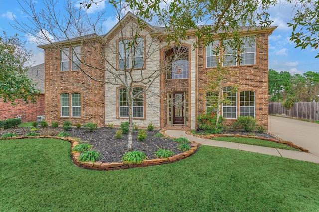 view of front of house with central AC unit and a front yard