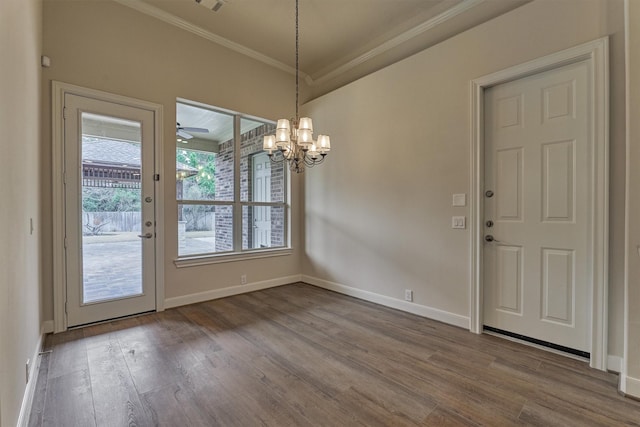 unfurnished dining area featuring crown molding, hardwood / wood-style floors, and a notable chandelier