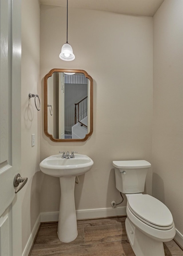 bathroom with toilet and hardwood / wood-style floors