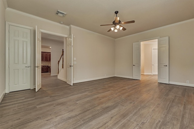 spare room with hardwood / wood-style flooring, ceiling fan, and ornamental molding