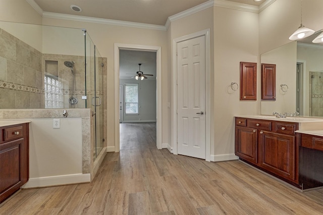 bathroom with wood-type flooring, ornamental molding, vanity, and walk in shower