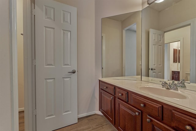 bathroom featuring vanity, wood-type flooring, and toilet