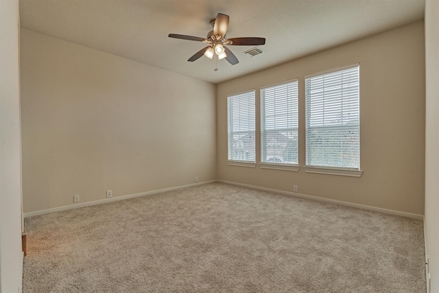 carpeted spare room with ceiling fan