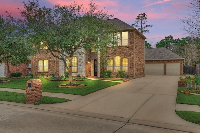 view of front of property with a garage and a lawn