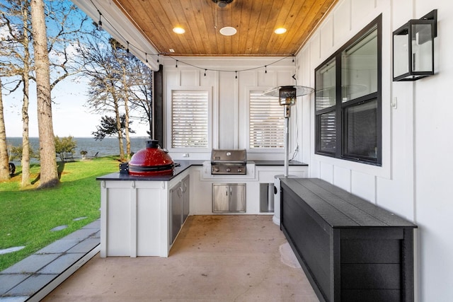 view of patio with area for grilling and a water view