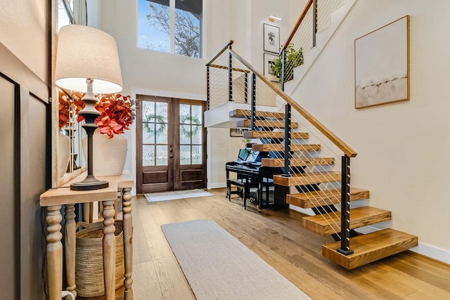 entryway with hardwood / wood-style flooring, french doors, and a high ceiling