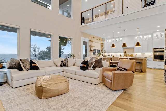 living room with light hardwood / wood-style floors and a water view