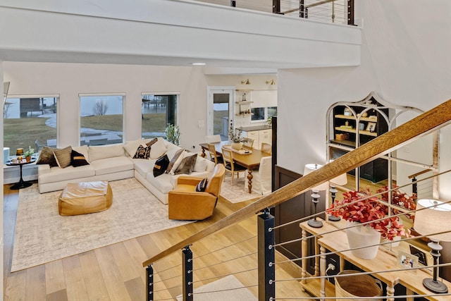 living room with hardwood / wood-style floors and a towering ceiling