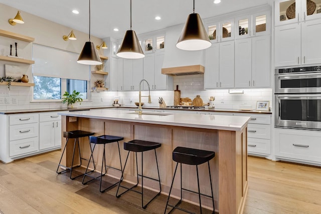 kitchen featuring white cabinetry, appliances with stainless steel finishes, sink, and a kitchen island with sink