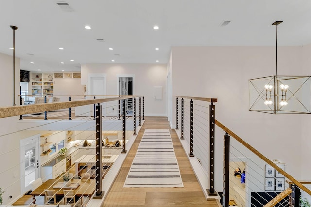 staircase featuring hardwood / wood-style floors and a notable chandelier