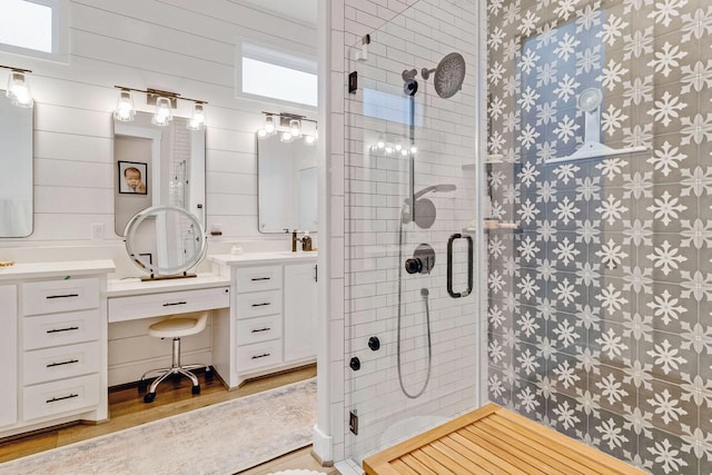 bathroom with a shower with door, vanity, and hardwood / wood-style floors