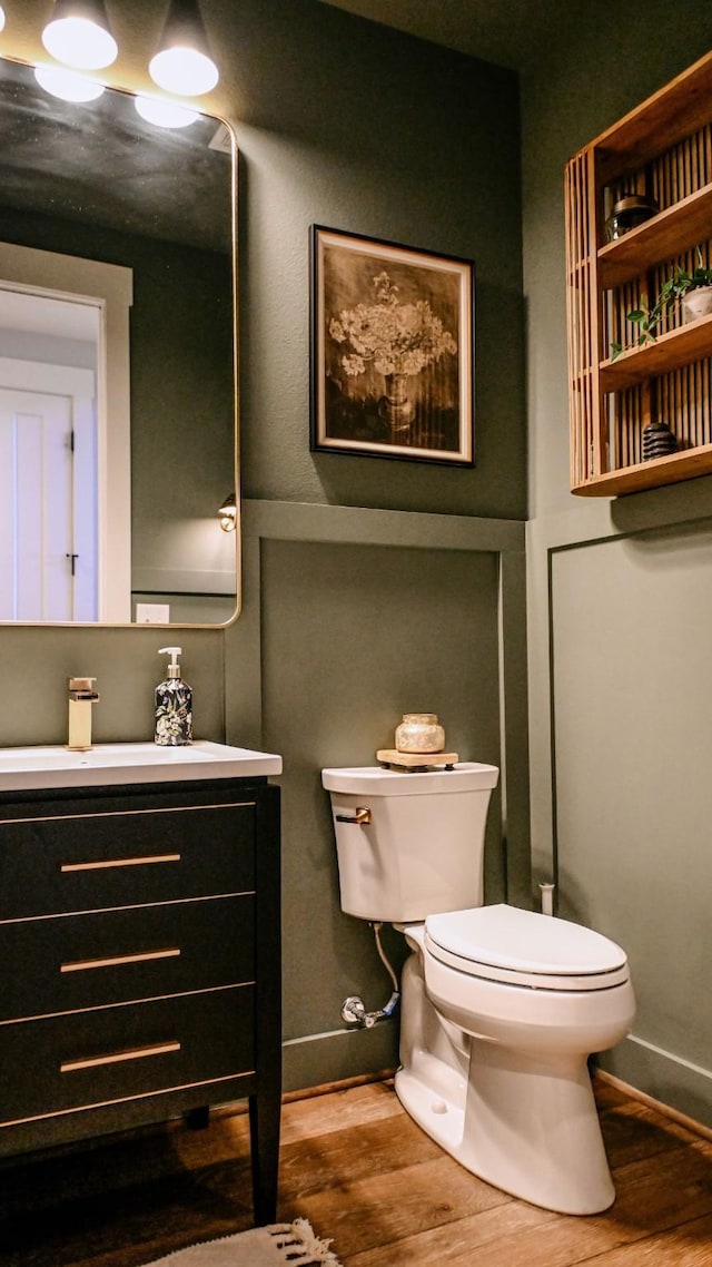 bathroom with hardwood / wood-style flooring, vanity, and toilet