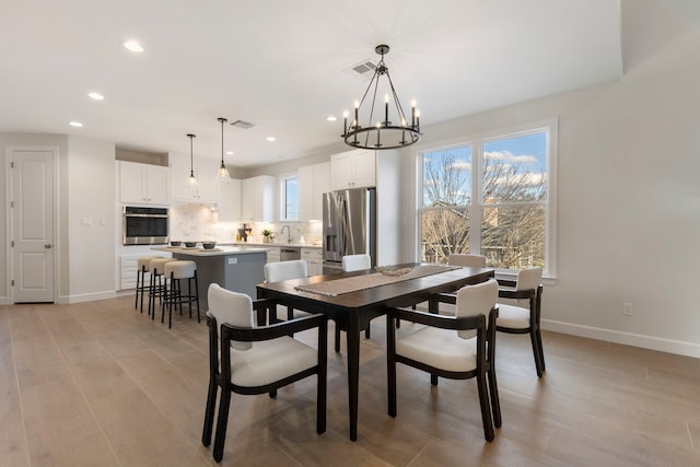 dining room featuring light hardwood / wood-style floors and a chandelier