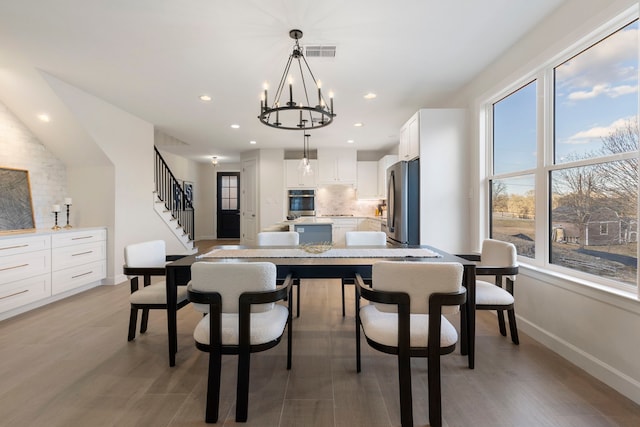 dining area with a notable chandelier and light wood-type flooring