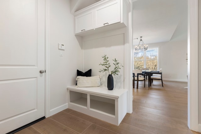 mudroom with a notable chandelier and light wood-type flooring