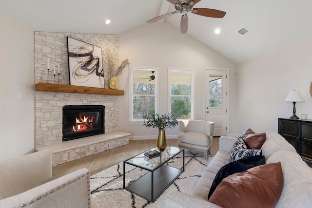 living room with lofted ceiling, a fireplace, ceiling fan, and light wood-type flooring