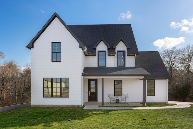 view of front of property featuring covered porch and a front yard