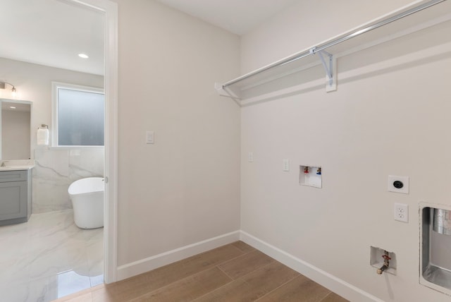 washroom with electric dryer hookup, hookup for a gas dryer, hookup for a washing machine, and hardwood / wood-style flooring