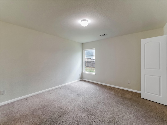 carpeted empty room featuring a textured ceiling