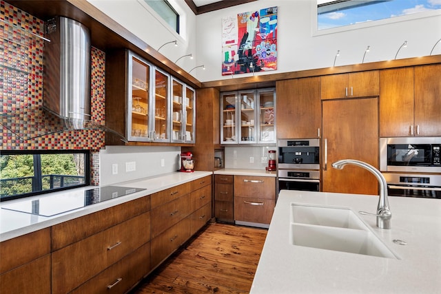 kitchen featuring sink, dark hardwood / wood-style flooring, stainless steel appliances, decorative backsplash, and a high ceiling