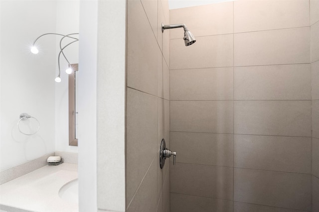 bathroom featuring a tile shower and vanity