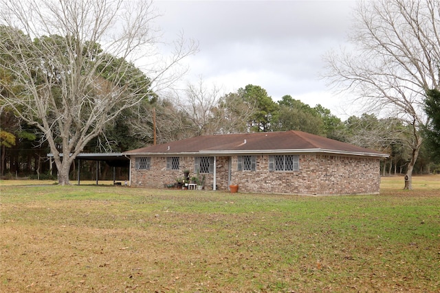 rear view of house with a carport and a yard