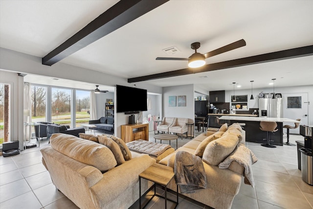 tiled living room featuring ceiling fan and beam ceiling