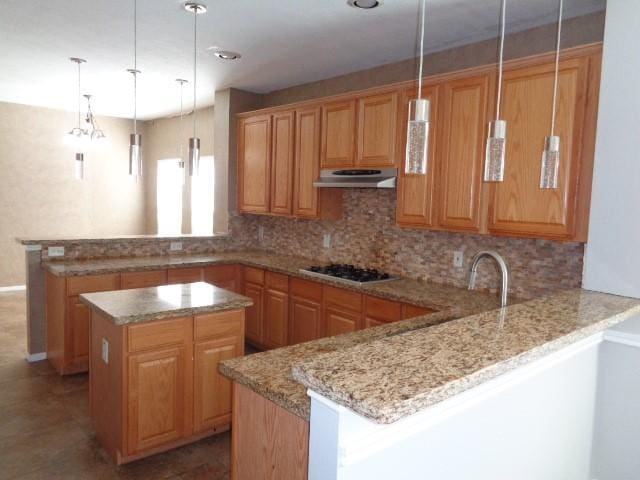 kitchen featuring gas cooktop, kitchen peninsula, hanging light fixtures, and a kitchen island