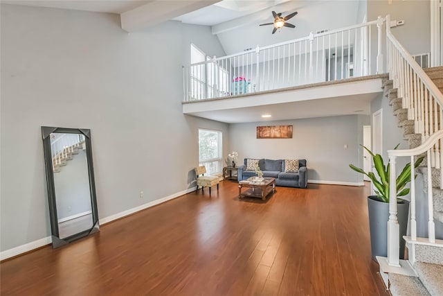 living room featuring dark hardwood / wood-style flooring, ceiling fan, high vaulted ceiling, and beamed ceiling