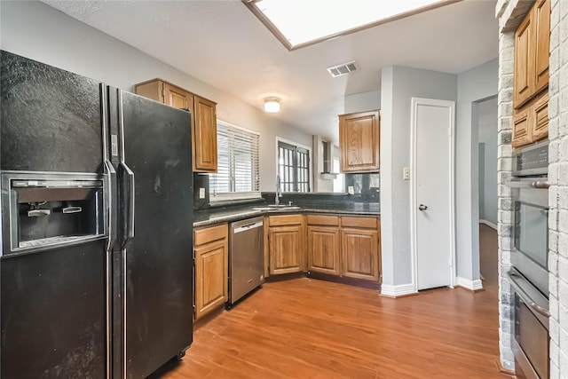 kitchen with sink, hardwood / wood-style flooring, and stainless steel appliances