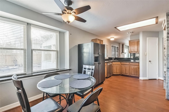 dining room with sink, hardwood / wood-style flooring, and ceiling fan