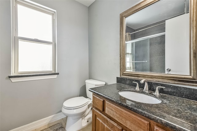 bathroom with walk in shower, vanity, and toilet