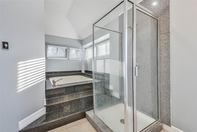 bathroom with independent shower and bath, vaulted ceiling, and tile patterned floors